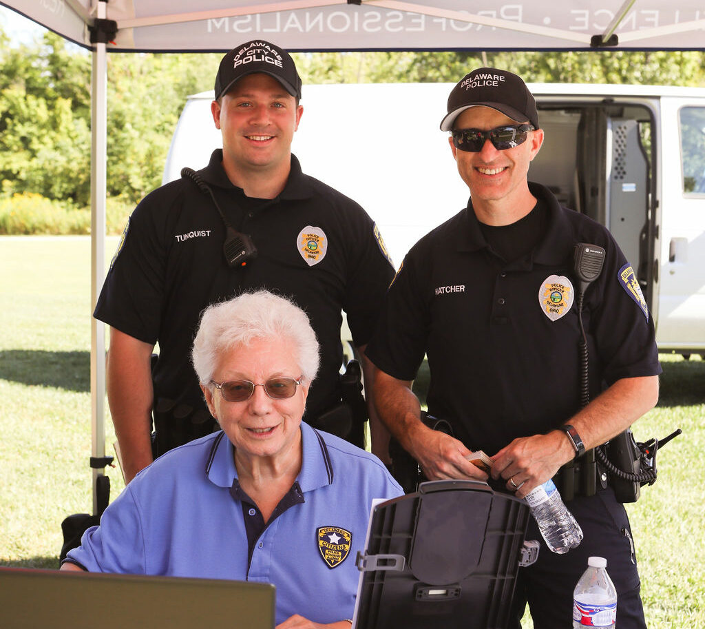 Delaware City Police Officers smile with Citizens Academy Volunteer